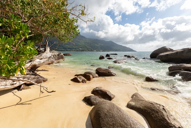 Granitfelsen und flaches Wasser am Strand Beau Vallon auf Mahé