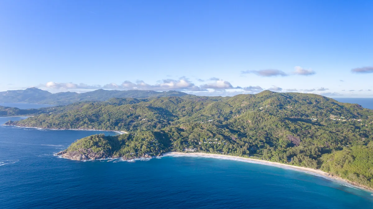 Strand Anse Intendance und bewaldete Hügel auf Mahé, Seychellen
